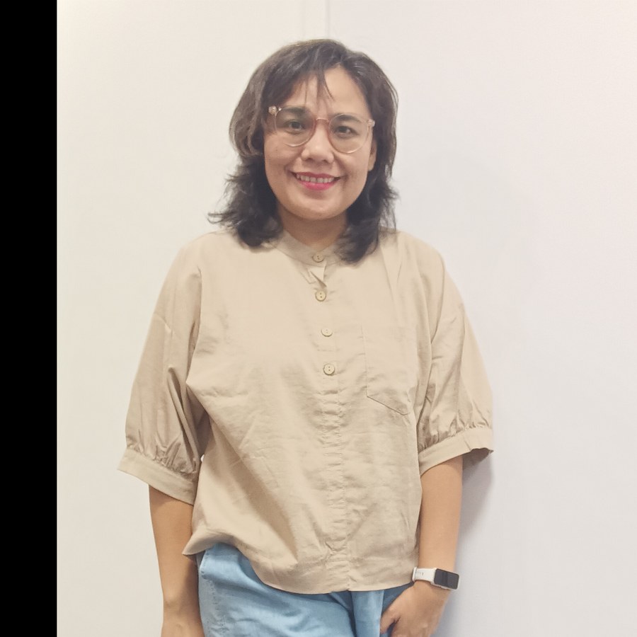 Devina, virtual assistant, wearing round pale-pink glasses and a beige shirt